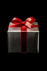 Wall Mural - Luxurious Silver Gift Box with Red Ribbon on Black Background - Perfect for Elegant Holiday Designs