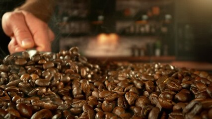 Aufkleber - Super Slow Motion of Male Hands Pouring Coffee Beans from Spoon. Filmed on High Speed Cinema Camera, 1000 fps. Blur Kitchen Industrial Interior on Background.