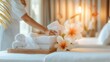 © Premium_art - Hands arranging towels and flowers in a serene spa setting. Wellness and relaxation concept with soft focus.