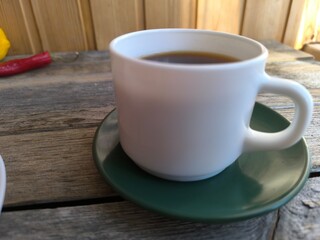 white cup of coffee on a green saucer. High-quality photos