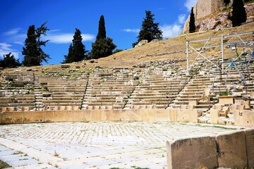 Remains of marble benches from the ancient greek amphitheater of the god dionysus on the hill of the acropolis in athens, greece. Sightseeing and vacation in greece 