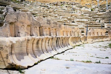 Remains of marble benches from the ancient greek amphitheater of the god dionysus on the hill of the acropolis in athens, greece. Sightseeing and vacation in greece 