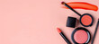 © Hamid - top view of makeup products against a pale pink backdrop