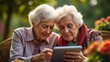 © Kateryna - two elderly people looking at a tablet together while sitting in the garden