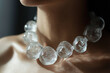 © Klay - close-up of a clear bubble ice  necklace on a woman's neck, highlighting sophisticated fashion style