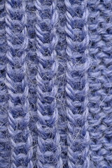 macro texture of purple crocheted sweater as a background, close-up of purple crocheted front surface, woolen texture of alpaca wool crocheted  