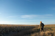 © Budjak Studio - Mature man hunter with gun while walking on field.
