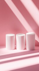 Poster - Three white cylindrical objects on a pink background with shadows, abstract design concept