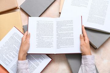 Poster - Female hands holding open book on beige background