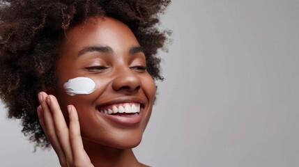 An African American woman carefully smears her face with cream. Facial skin care concept, copy space