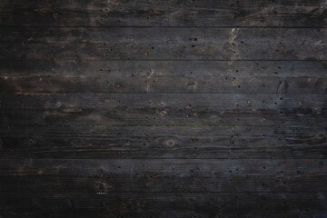 Rustic, dark wood surface aged texture showcases intricate grain patterns. Charred and weathered, planks reveal vintage, earthy warmth, creating natural, organic feel reminiscent of firewood.