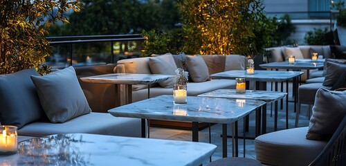 Refined rooftop terrace with marble tables, comfortable seating, and ambient light.