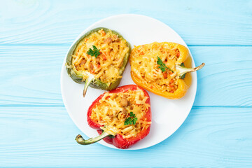 Wall Mural - Baked stuffed pepper ( paprika ) with rice , carrot and meat . Top view on rustic background