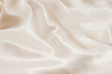 Nude beige texture of silk, folds on the fabric, space for text