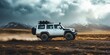 © Bambalino Studio - A white jeep is driving through a desert with a cloudy sky above. The jeep is covered in mud and dust, and it is going fast. Concept of adventure and excitement