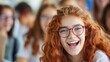 © liliyabatyrova - A girl with red hair and glasses is smiling and laughing