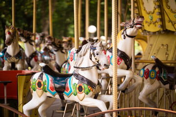 A children's attraction in the park, a carousel with horses on a sunny day, no people.