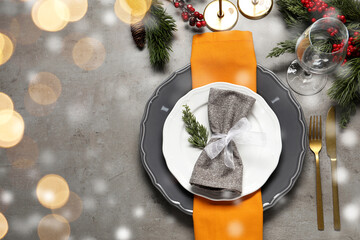 Wall Mural - Plates, cutlery and Christmas decor on grey table, flat lay. Space for text. Bokeh effect