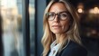 © Vilaphon  - A close-up of a businesswoman holding a tablet in an open-plan office with a focused, professional expression