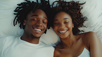 Poster - Happy young couple sharing a lighthearted moment on a white bed, their smiles showing warmth and love.