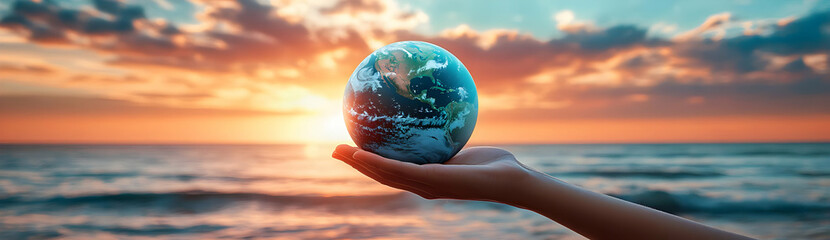 A hand holding a globe at sunset, symbolizing hope and sustainability in a vibrant and peaceful natural setting.