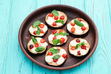 Wall Mural - Italian mini pizza . Aubergine (eggplant ) with mozzarella cheese and basil . On rustic background