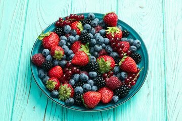 Wall Mural - Mix of ripe colorful berries in bowl photography . Blueberry , strawberry , raspberry , blackberry and red currant . Top view