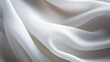 © Prapan - A close-up image of clean, white cotton fabric draped softly, revealing the gentle folds and curves. The surface is immaculate and free of imperfections,
