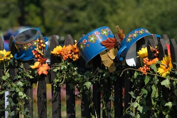 Wall Mural - Two blue metal pots decorated with flowers on wooden fence in countryside