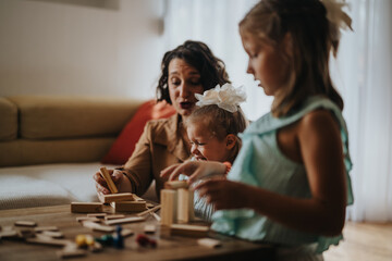 A joyful moment as a mother and her two daughters engage in a fun and creative play session, building with wooden blocks at home.