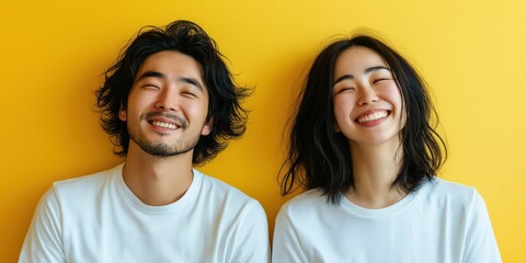 A studio close-up portrait of a young Asian couple wearing casual t-shirts, with a colourful background.