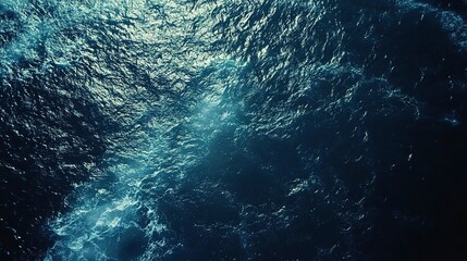 Poster - A bird's eye view of a dark blue ocean, the water rippling and glistening in the sunlight