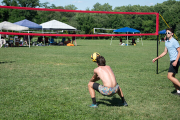 Wall Mural - Male volleyball players playing grass doubles