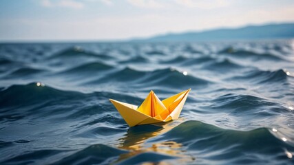 yellow paper boat floating on blue water, sunny day.