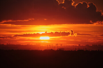 Sunset over city skyline with orange and red clouds. Landscape photography. Evening and nature concept for design and print