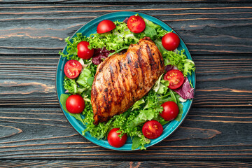 Wall Mural - Grilled chicken breast ( fillet ) with lattuce salad and cherry tomatoes . Top view