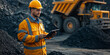 © T-elle - Mining Operator Controls Loading. Mining engineer in a hard hat monitors the loading of coal or cargo into a dump truck.