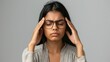 © Samady - Tired stressed indian business woman feeling headache dry eye strain holding glasses isolated on grey studio background, upset fatigued hindu girl take off eyewear having bad vision problem concept