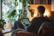 © Aditya - Man in casual attire working on a tablet in a cozy home office, relaxed and productive environment, natural light