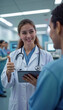 © Juan Mari - Smiling female doctor showcases new medical technology on a tablet while discussing with a colleague in a modern hospital. Ideal for promoting healthcare innovations, medical articles, and technology