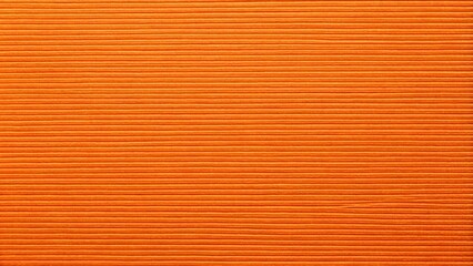 Closeup texture of dense carrot-colored paper resembling bright orange cardboard