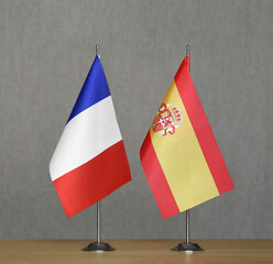 Table flags of France and Spain on a gray blurred background