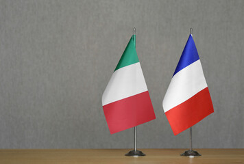 Table flags of France and Italy on a gray blurred background