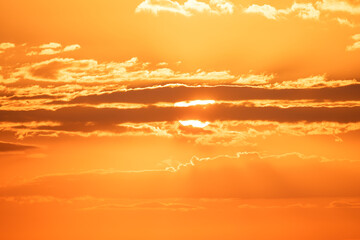 Wall Mural - cloudscape and dramatic orange sky, sunrise shot, sun rising up behind scenic morning clouds