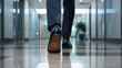 © Anna - A professional man strolls down a sleek office corridor, showcasing his polished dress shoes while surrounded by contemporary architecture and indoor plants
