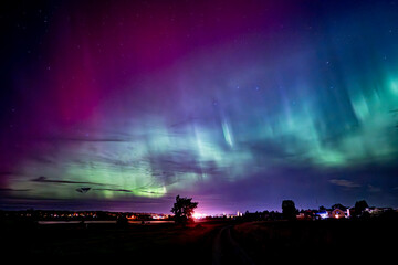 Wall Mural - northern lights dancing over the sky sky in the country road