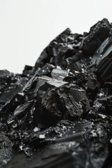 Poster - A pile of dark stones sits on a clean white surface, perfect for use in minimalist or abstract designs