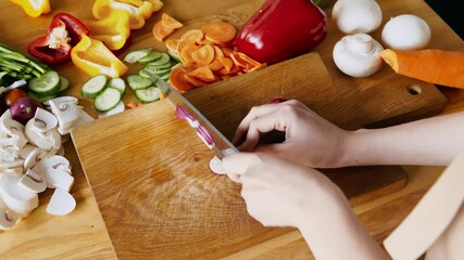 Wall Mural - Woman cutting fresh radish on kitchen cutting board, top view