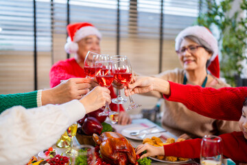 Asian family on Christmas Day. Everyone is happy together in a Christmas themed room filled with presents and orange lights.