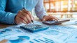 © Orxan - A businessman calculates company financial data using a calculator, analyzing historical performance to strategize future growth